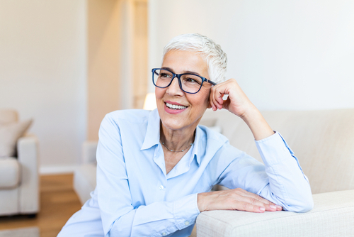 An elderly woman smiling with glasses